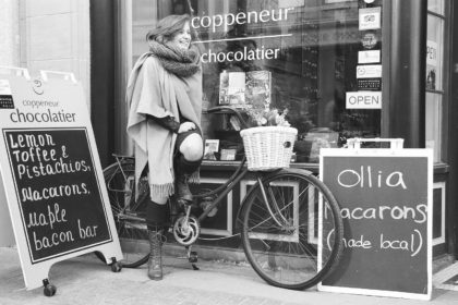 young woman on a bicycle at a chocolatier