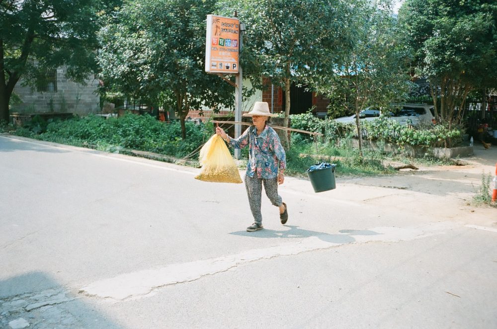 a woman crossing the street in the Yangshuo countryside