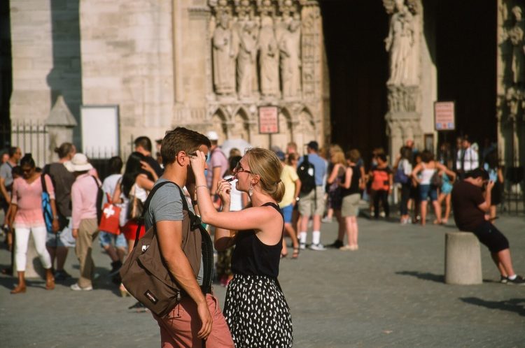 applying lipstick in sunglasses reflection