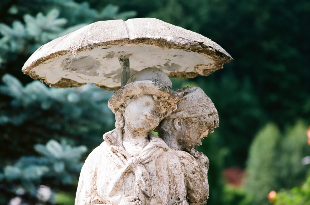 statue of kids under an umbrella up close